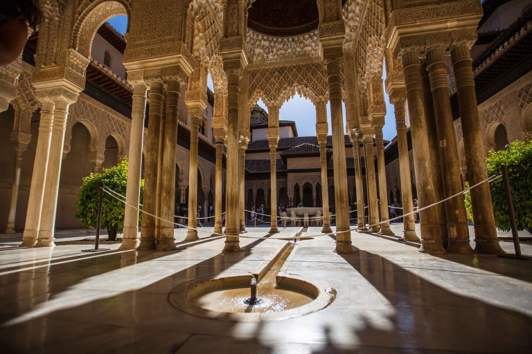 Courtyard with carved arches, central fountain, and stone columns.